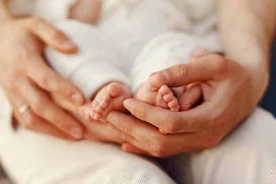 Mãos segurando os pés de um recém-nascido