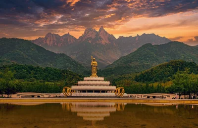 Estátua e montanhas ao amanhecer